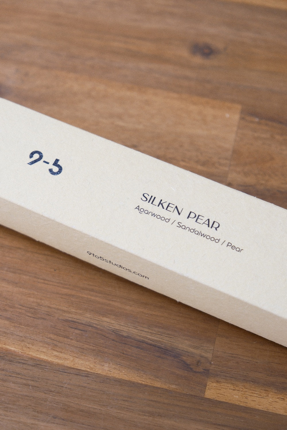 Closed cream Silken Pear incense box on dark walnut wood