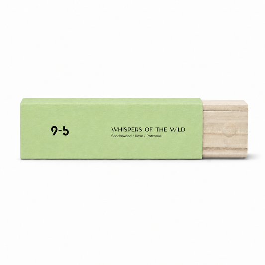 Coral red gift bag behind stack of pastel incense boxes on wooden stool with palm plant