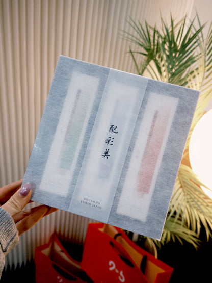 Sealed Kousaido HISAIBI incense gift set held upright near green plant leaves at 9to5 Studios