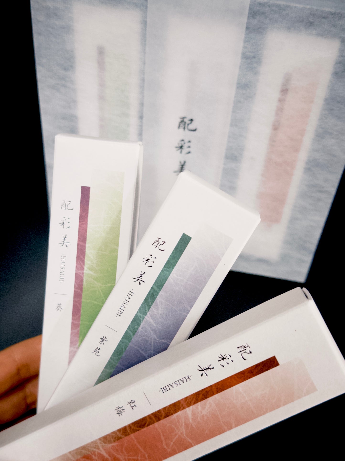 Hand holding Kousaido incense packages showing detailed gradient colors and text at 9to5 Studios