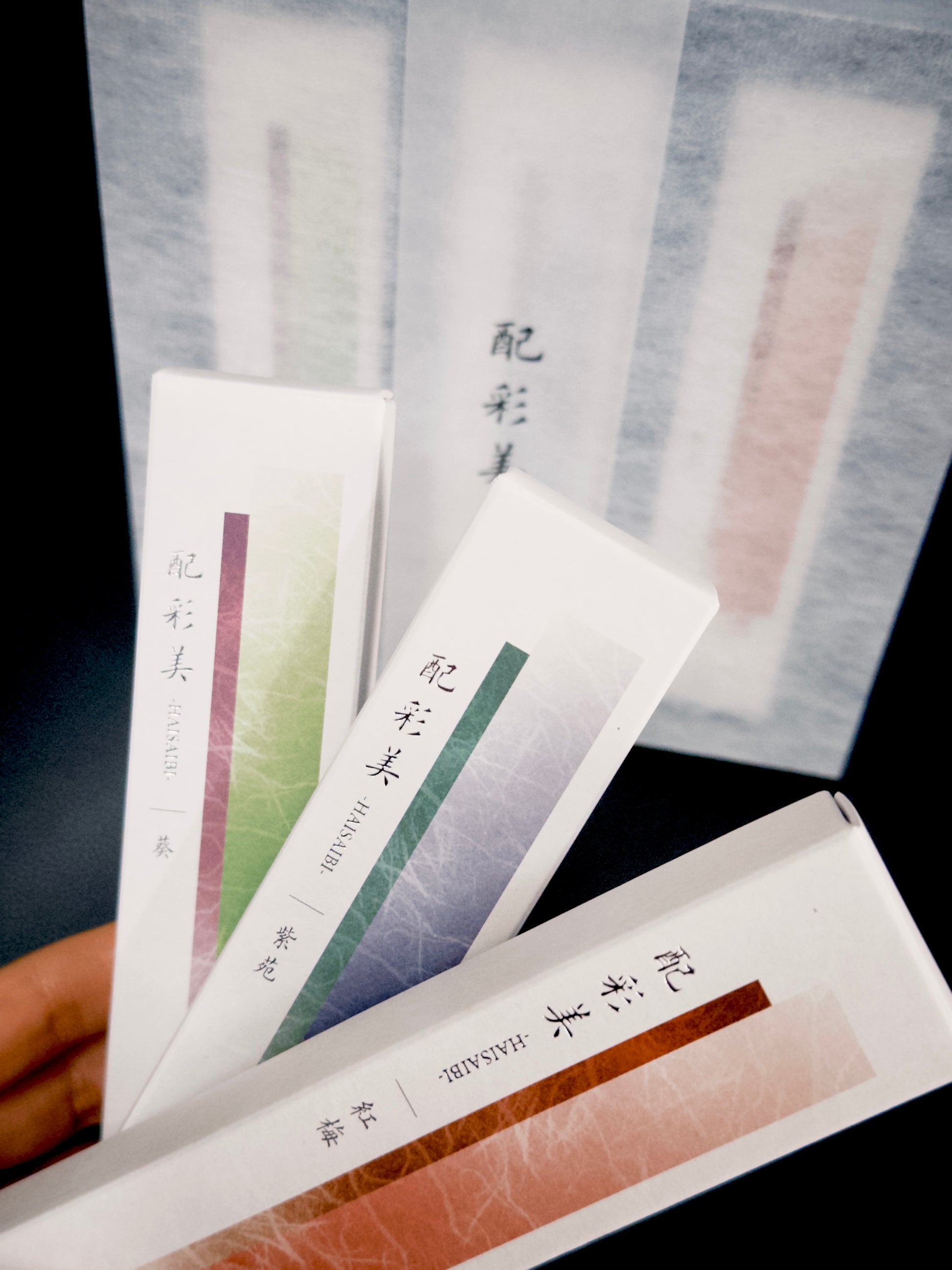 Hand holding Kousaido incense packages showing detailed gradient colors and text at 9to5 Studios