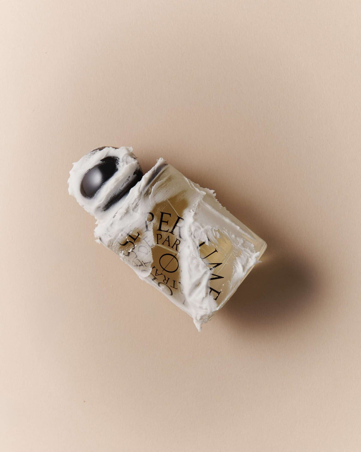 Odesse Crème Santal Extrait De Parfum by 9to5 Studios clear glass bottle with black cap and cream smear