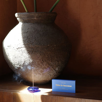 Light blue Gentle Habits incense box lifestyle shot with burning stick in cobalt holder and terracotta vase by 9to5 Studios