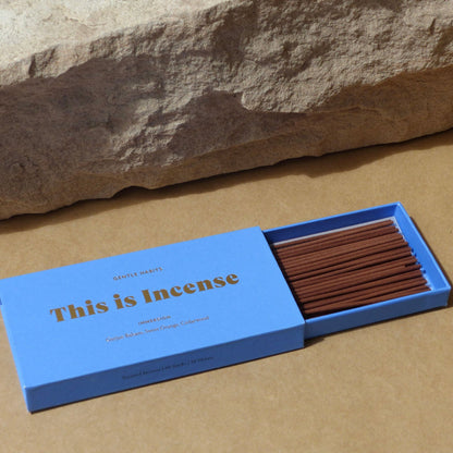 Close-up of open blue incense box with neat rows of sticks and natural stone element by 9to5 Studios