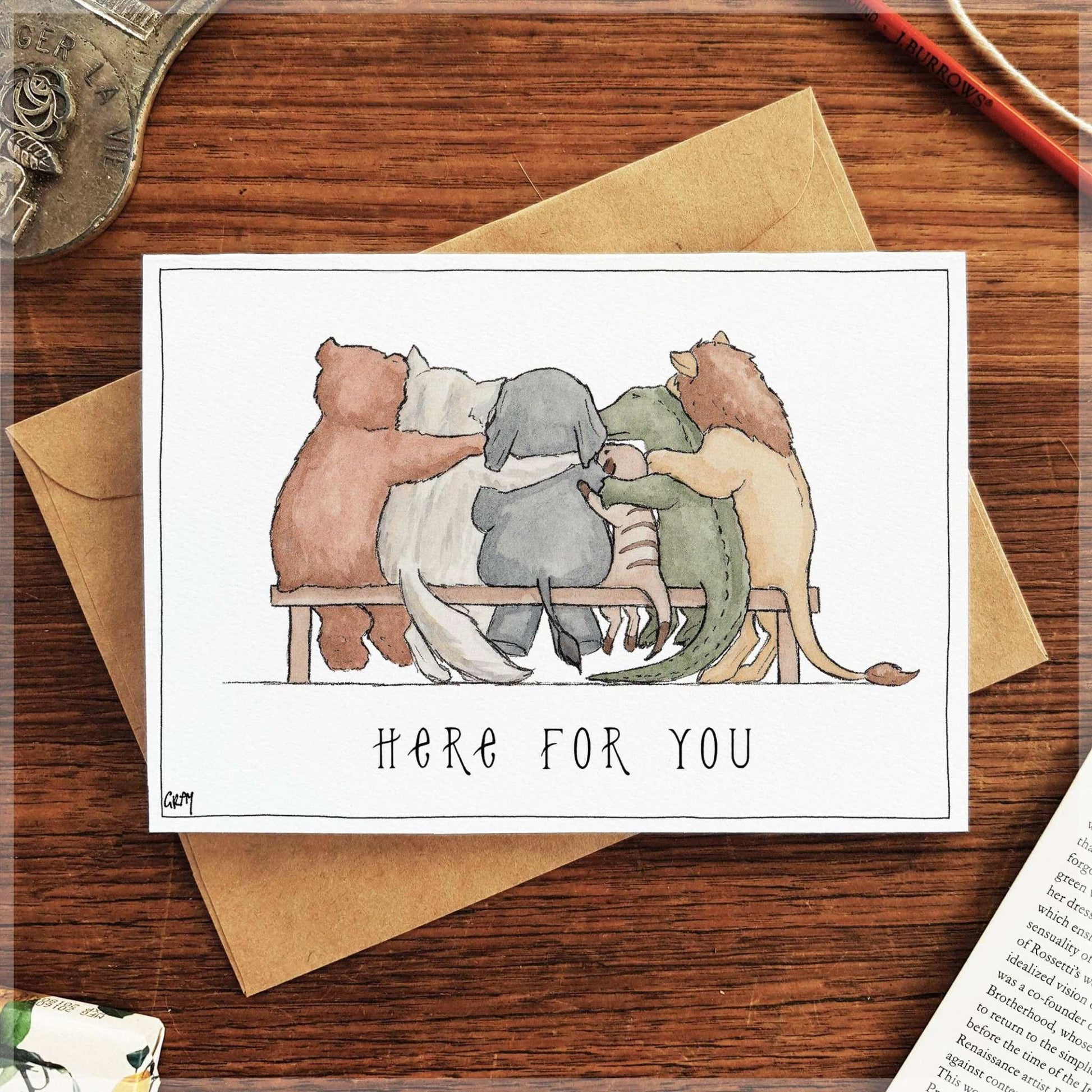 Here for You greeting card by 9to5 Studios featuring watercolour animals hugging on bench with kraft envelope
