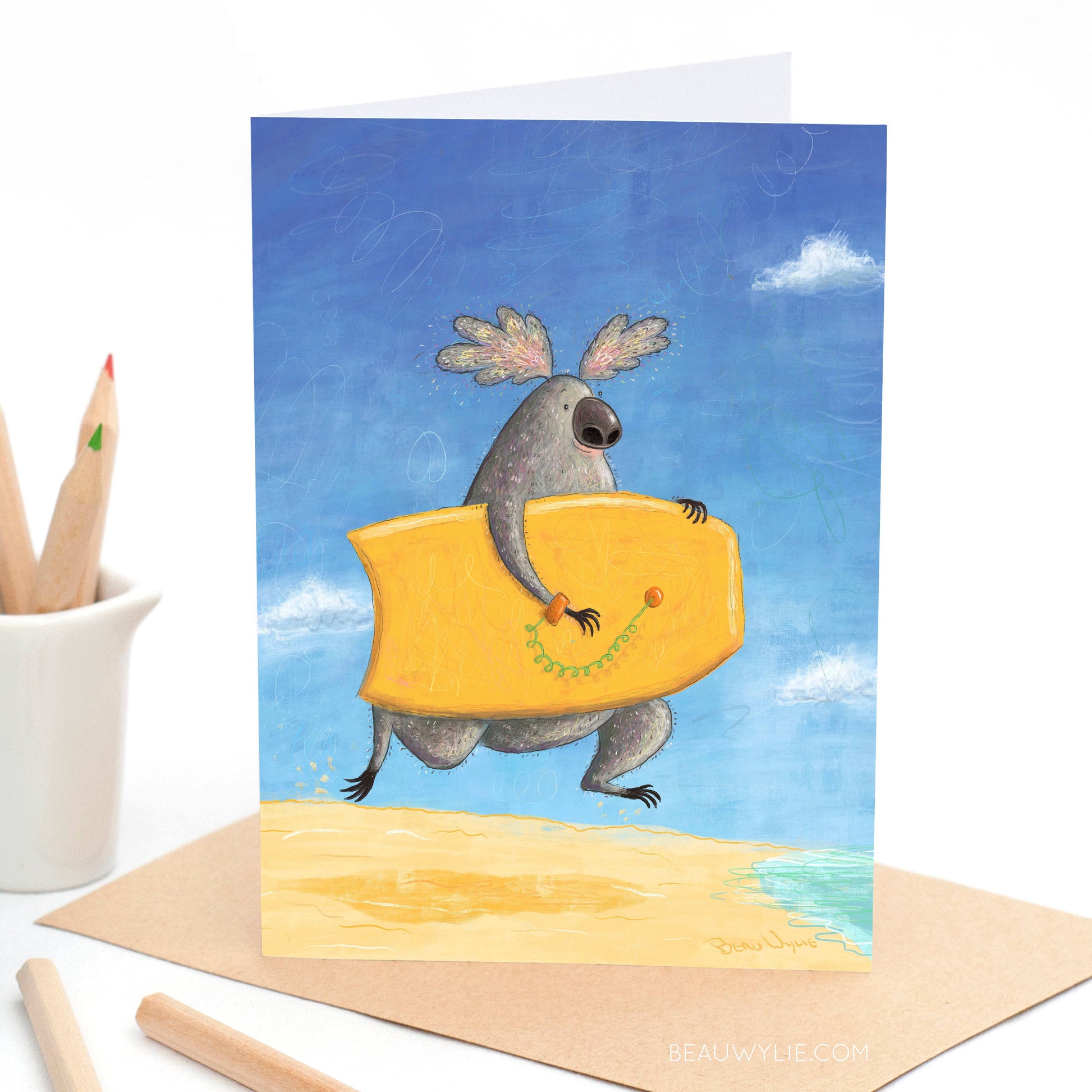 Koala Boogie greeting card by Beau Wylie for 9to5 Studios featuring gray koala on mustard boogie board with green leash