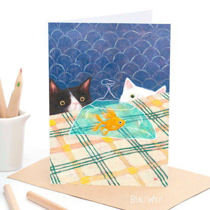 The Arrival greeting card by Beau Wylie from 9to5 Studios featuring black and white cats on plaid tablecloth with navy scalloped background