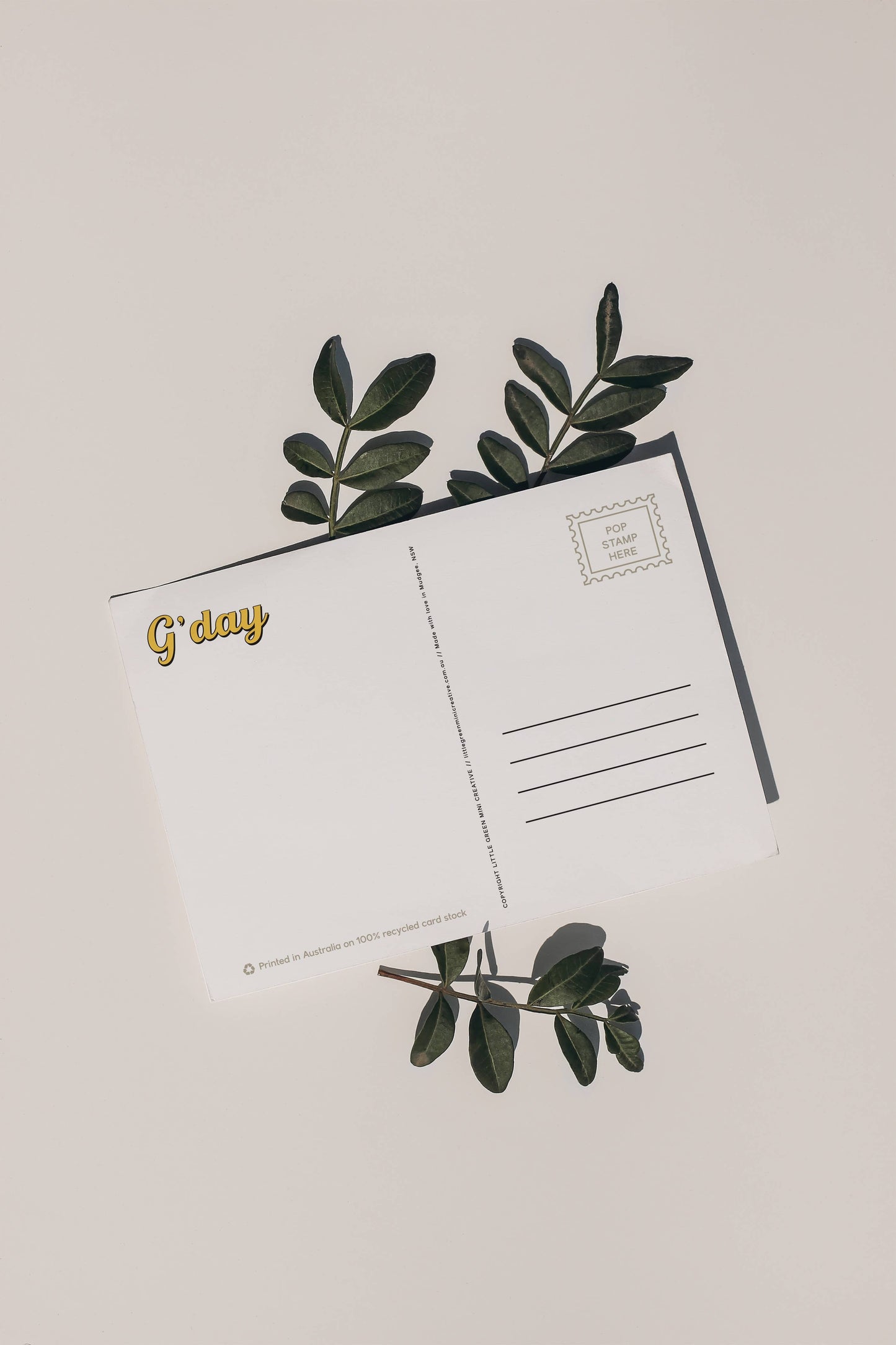 Back of 9to5 Studios Australia postcard displaying G'day gold script, stamp box, and address lines on white recycled stock