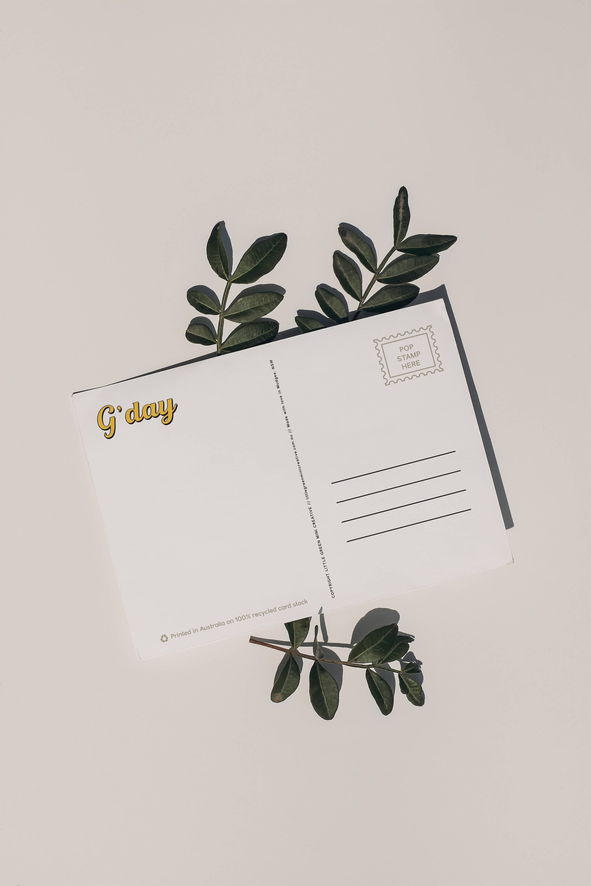 Back of 9to5 Studios Australia postcard displaying G'day gold script, stamp box, and address lines on white recycled stock