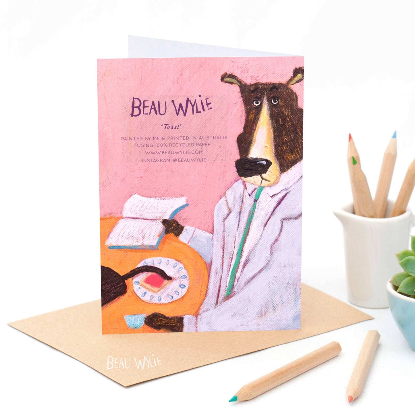 Toast greeting card by Beau Wylie for 9to5 Studios featuring whimsical bear in lab coat with cat tail on toast, recycled paper