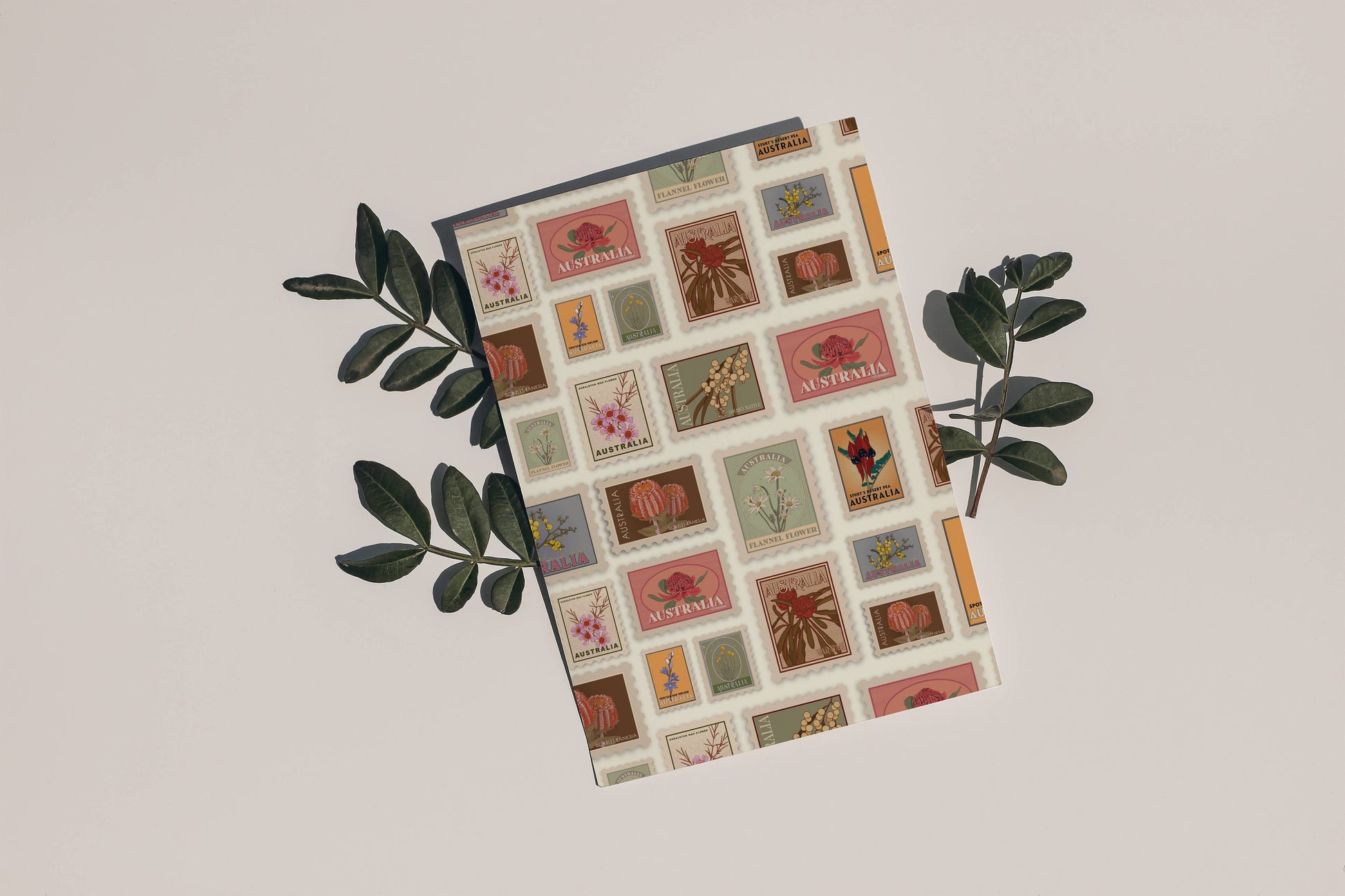 9to5 Studios A6 postcard with native plant stamps surrounded by eucalyptus leaves highlighting textured recycled paper design