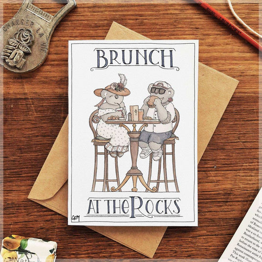 Greeting card featuring two dressed-up koalas dining at a table, ink and watercolour illustration titled Brunch at the Rocks.