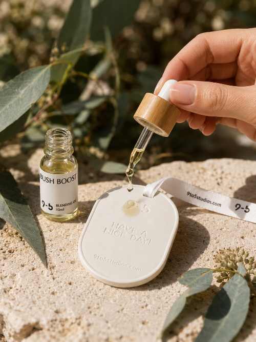 Hand holding a dropper over a small white device with greenery in the background